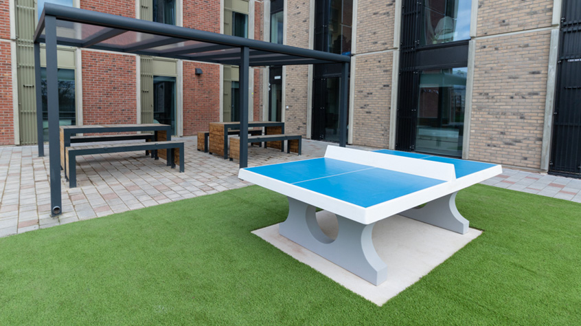 Outdoor social area with seating and table tennis