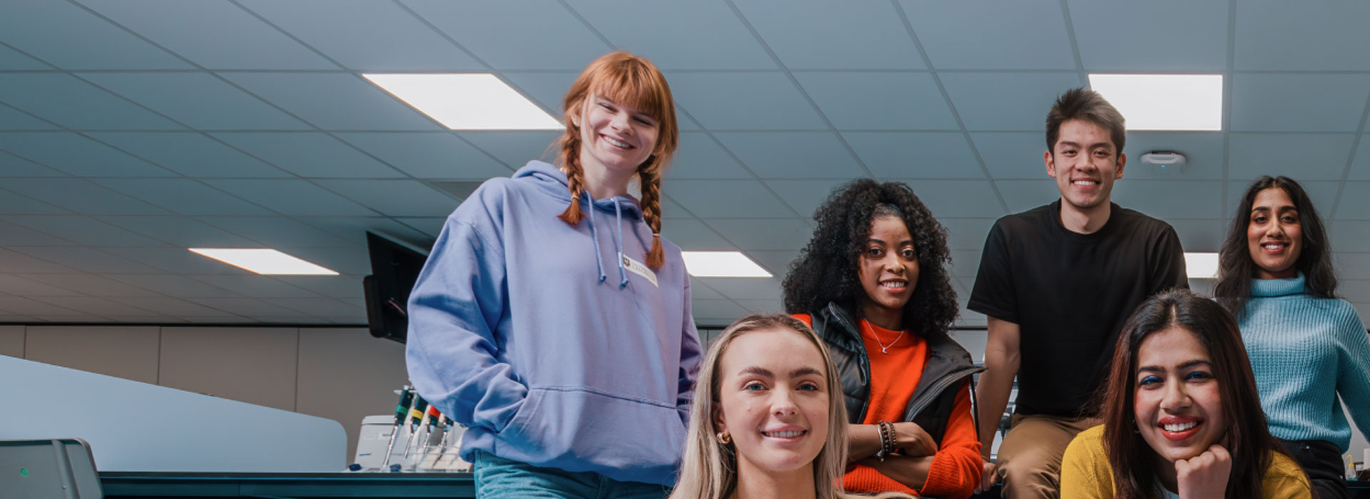 students sitting in a lab, posing for the camera