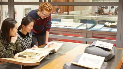 Students looking at archives with staff member