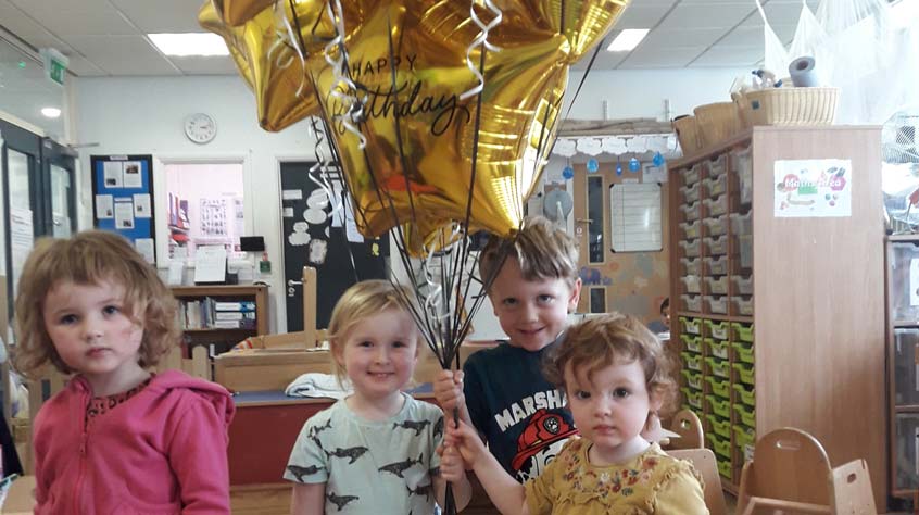 Children at the University of Leicester nursery holding balloons