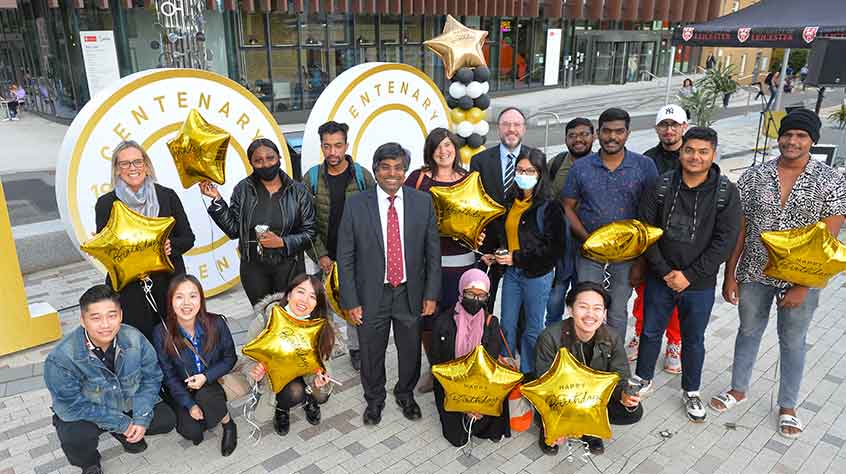 4/10/21 - VC Nishan Canagarajah gathers with students holding gold balloons, as they celebrate the University's 100th birthday