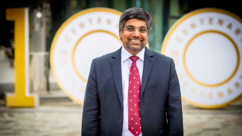VC Nishan posing in front of the centenary 'Our 100' sign 