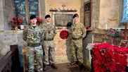Soldiers standing near poppy wreath