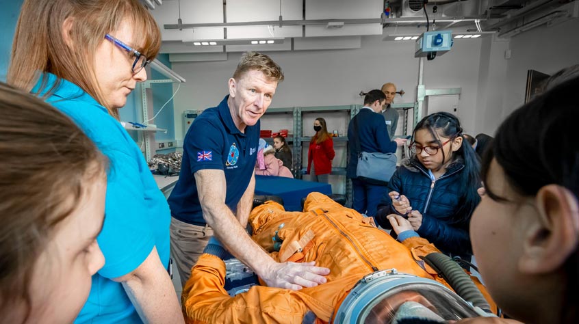 Major Tim Peake explaining the workings of an ESA spacesuit to local schoolchildren.