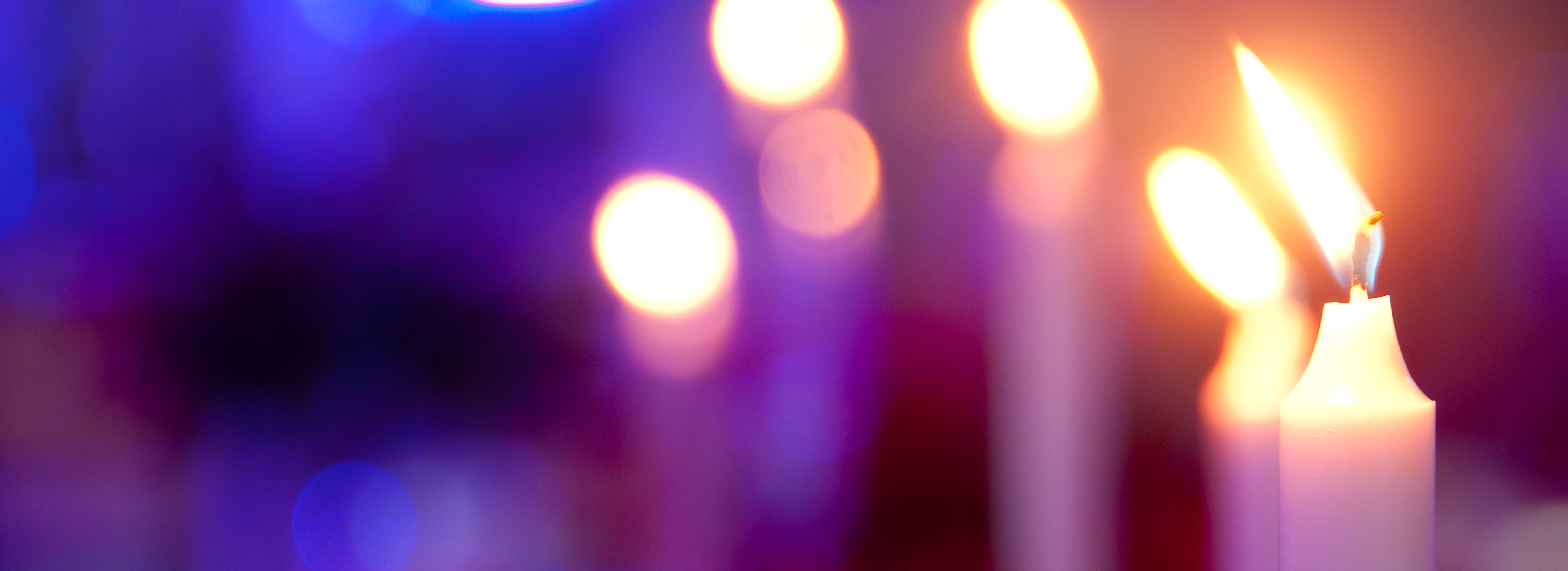 Lit candles against a purple background