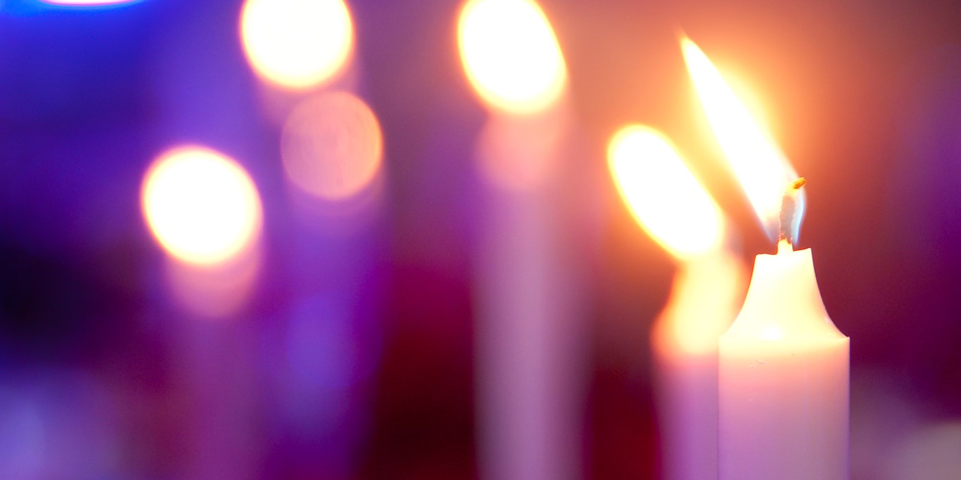 Lit candles against a purple background