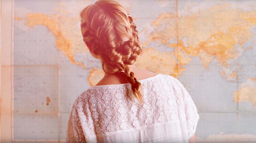 video still of student looking at wall map