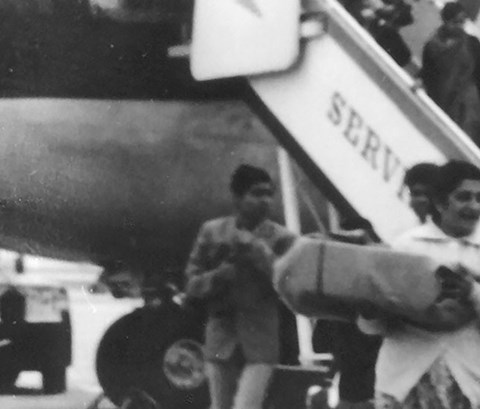 Black and white photo of people getting off a plane