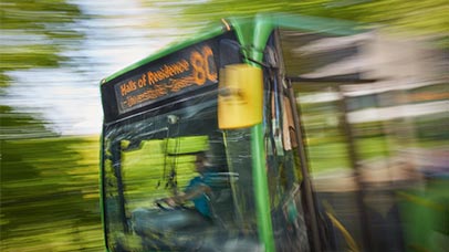 a bus in motion between halls and campus