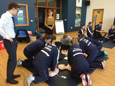 high school students practising CPR