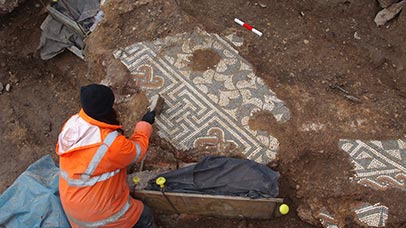 researcher uncovering a roman mosaic