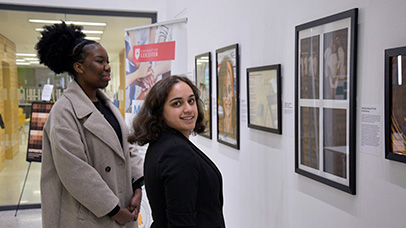 Two people looking at the MedRACE art exhibition