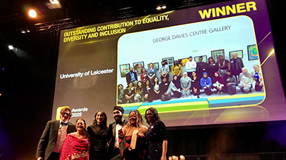 Staff and students at an award ceremony with photo of the MedRACE team behind