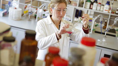 Lady standing in lab doing research
