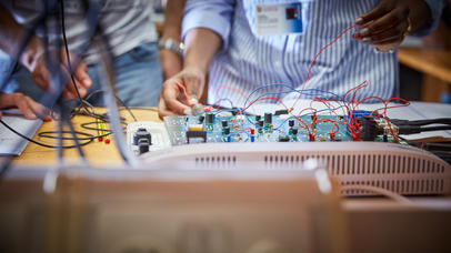 Physics students looking at a motherboard