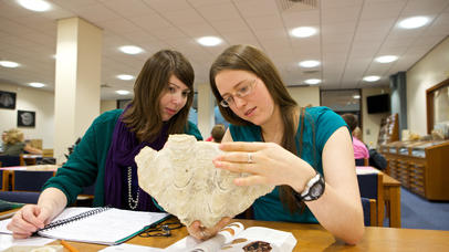 Two girls examine a rock