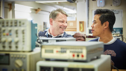 Two students face each other smiling