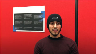 A student stands in front of a red screen talking about support offered at the University of Leicester