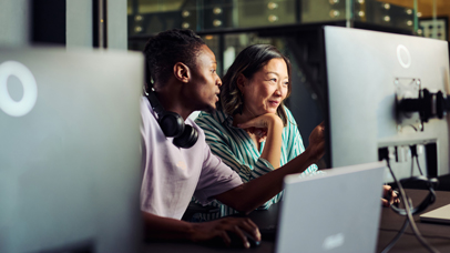 Two people discussing work at a computer screen