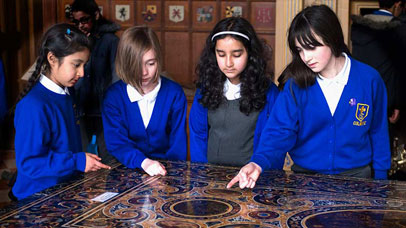 Four school children gathered round a museum exhibit