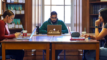 Three students studying at a table in the Law library.