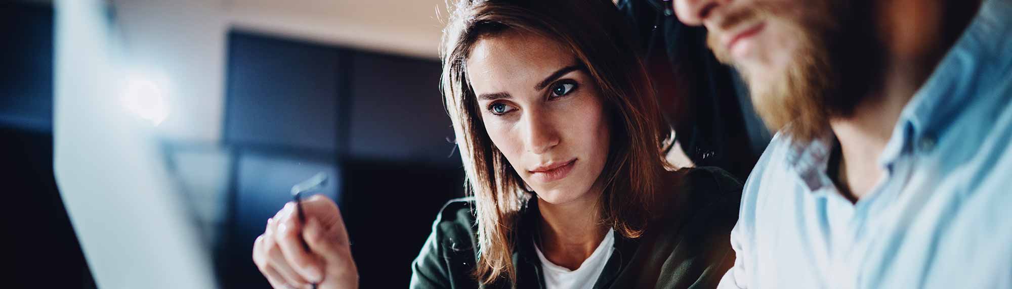 a manager working with staff at a laptop