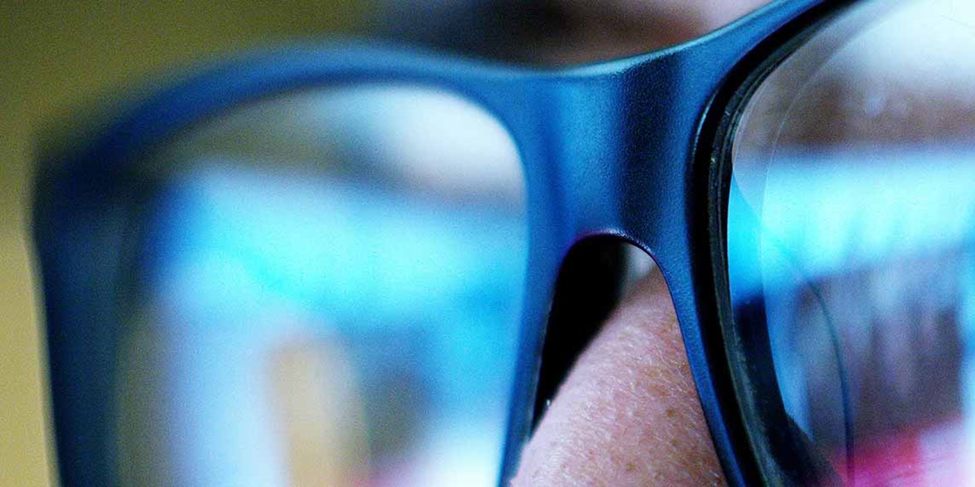 close up shot of someone wearing glasses looking at a screen