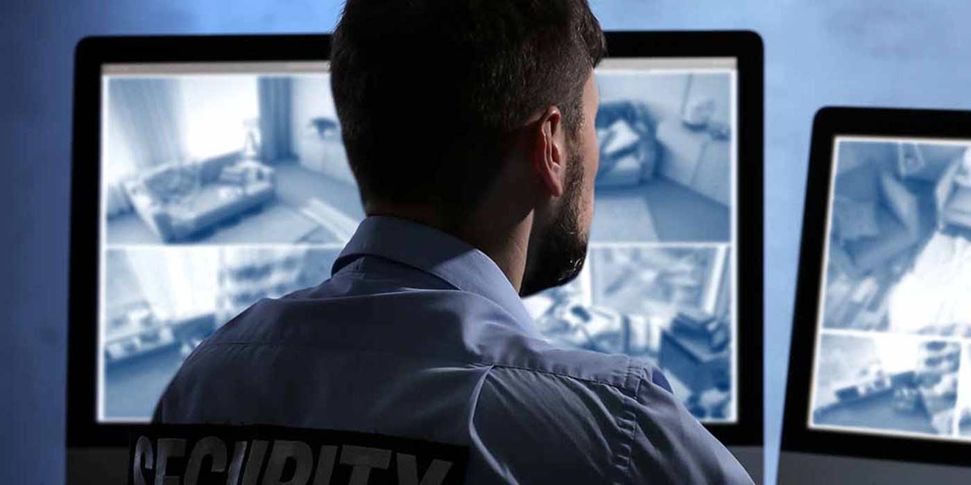 security guard watching banks of cctv footage