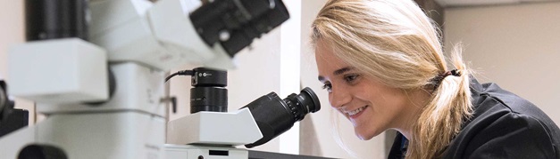 student using a microscope in class