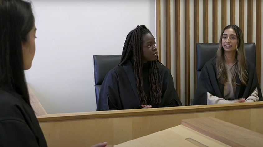 Students sat in a court room as part of the facilities within Leicester Law School