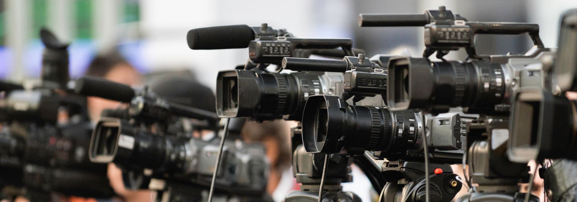 Close up crowd of journalists operating video cameras 