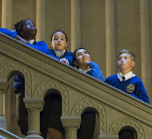 school children stood on a staircase looking across in different directions