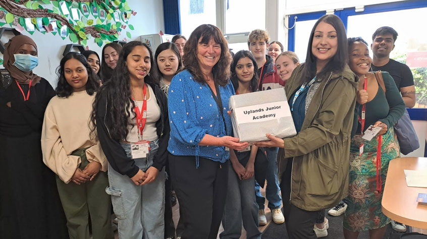 People standing together whilst one holds a certificate and all posing for the camera.