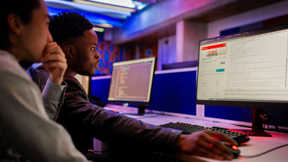 Two students working on the same computer in a computer lab