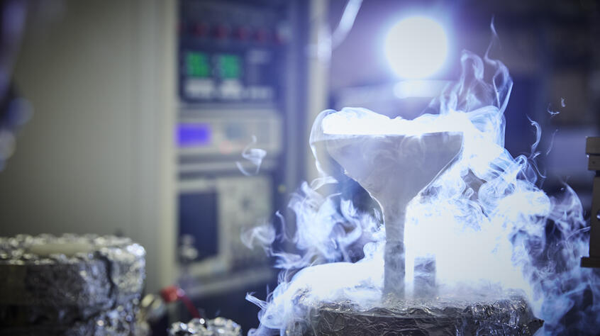 Close up photograph of chemistry experiment, showing white smoke cascading out of a funnel