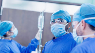 Three doctors in scrubs in surgery