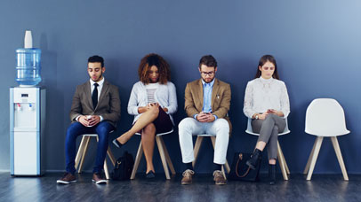 Four people sat in chairs waiting to be interviewed for a job