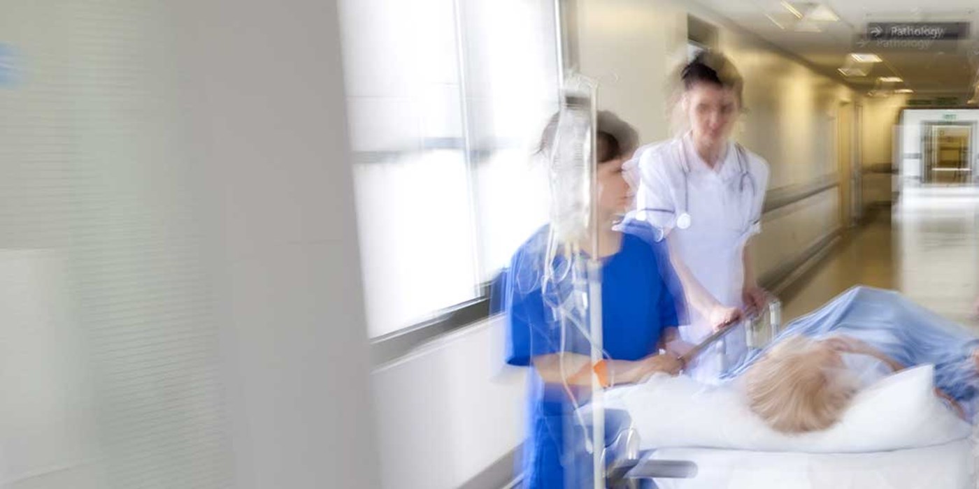 an elderly person being wheeled along in a hospital bed