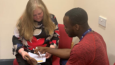 Photo: Research team member and patient discussing form