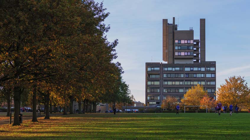 A view of the Attenborough building on Leicester campus from Victoria Park at dusk.