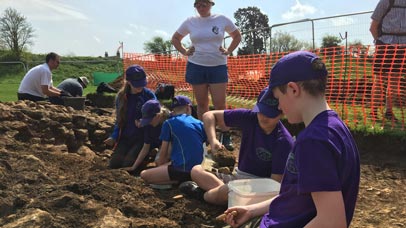 Group of children working on an excavation site.