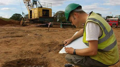 Archaeologist writing notes at a dig site