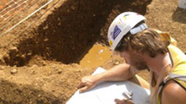Adam Clapton reviewing a map on a dig site