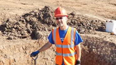 Leon Hunt holding a spade at a dig site