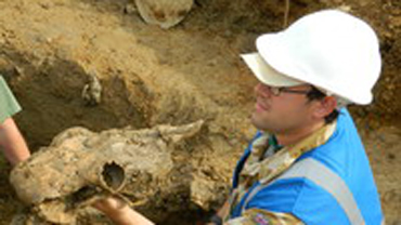 Nathan Flavell holding a fossil on a dig site