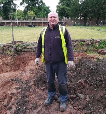 Andrew McLeish standing in the middle of an excavation site.