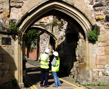 Two archaeologists surveying an archway