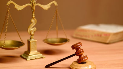 Scales, gavel and law book on table.