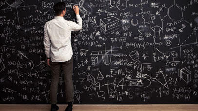 Man writing on a large blackboard with chalk