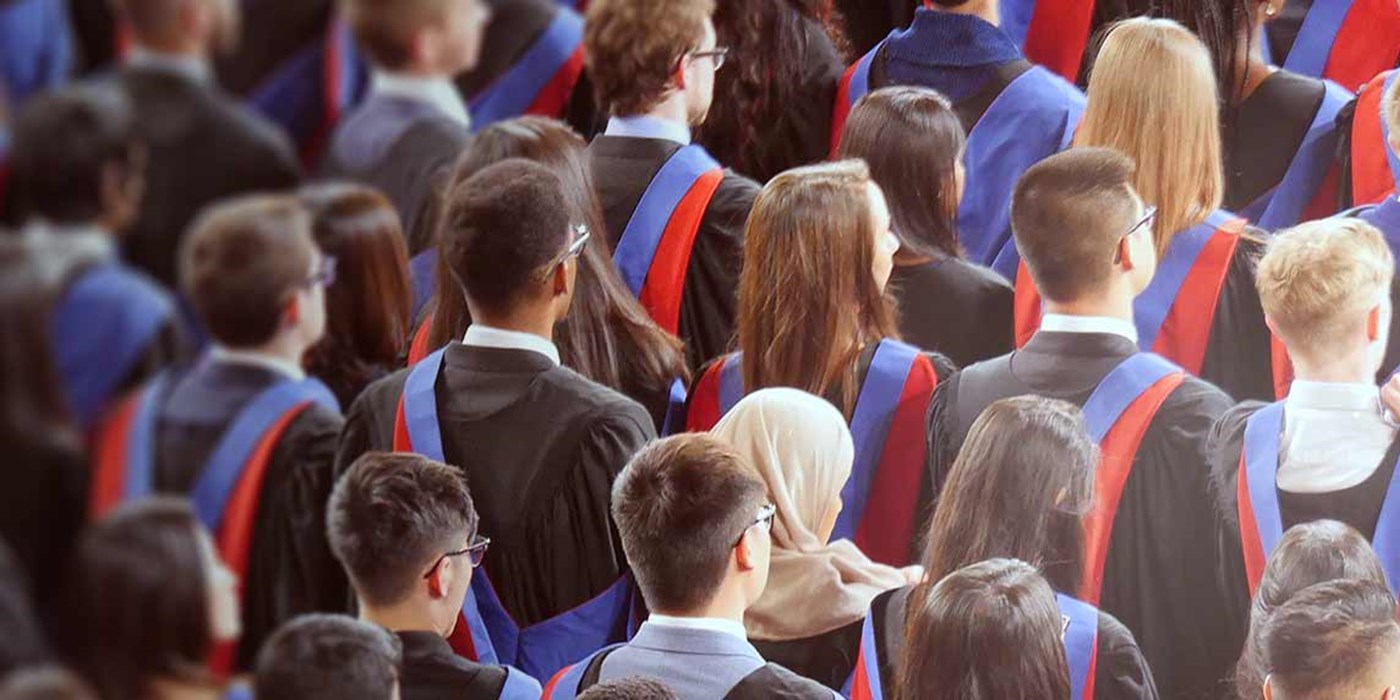a large group of students in robes at a graduation ceremony